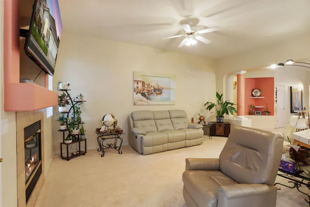 a living room with furniture a fireplace and a chandelier