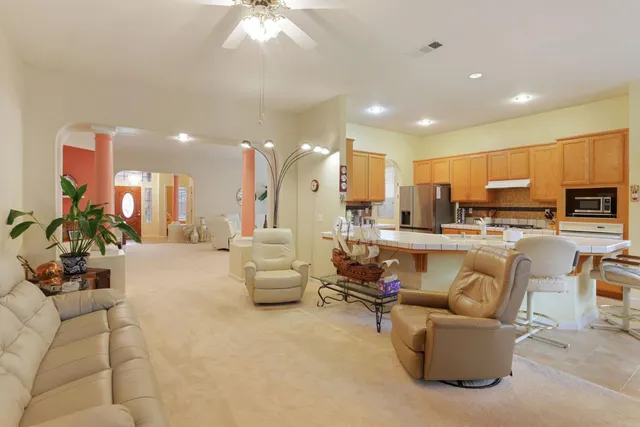 a living room with furniture a fireplace and a chandelier