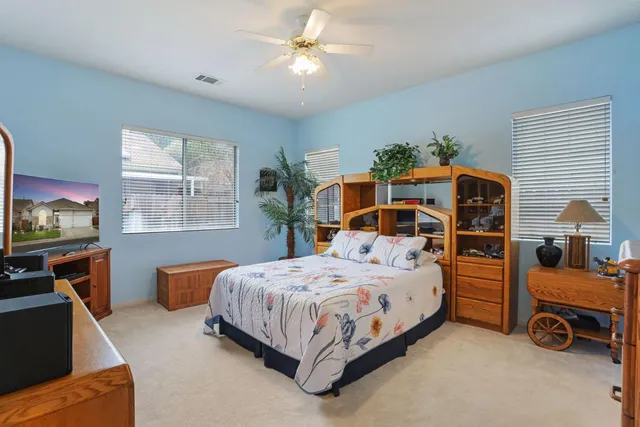 a bedroom with a bed and a large mirror with a dresser