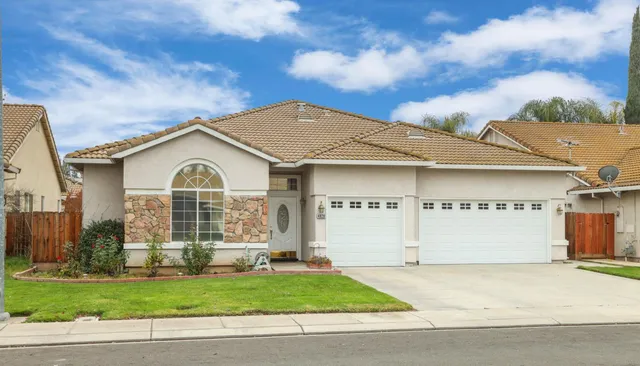 a view of a white house with large windows and a yard