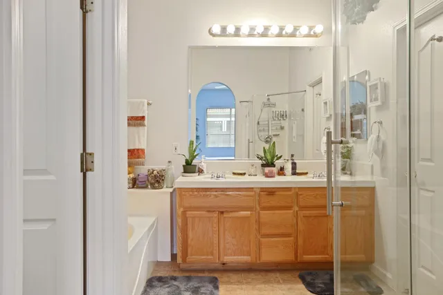 a bathroom with a tub a sink and a large mirror
