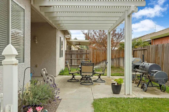 a view of a patio with a table chairs and a backyard