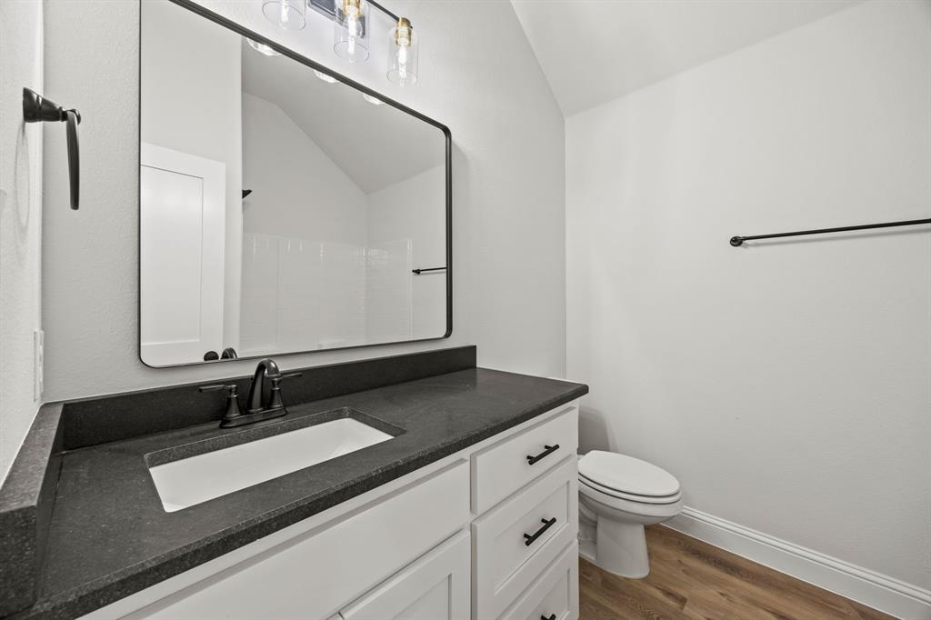 104 Maverick Trail Valley View, TX 76272 - Photo 22 of 30 a bathroom with a sink a toilet and mirror
