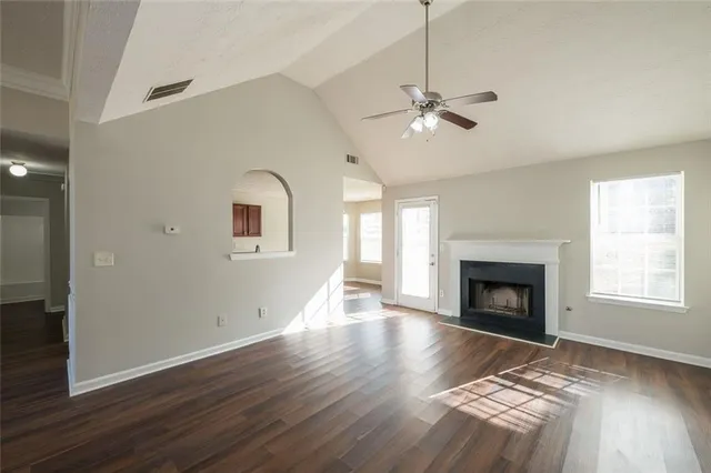 a view of empty room with wooden floor fireplace and a window