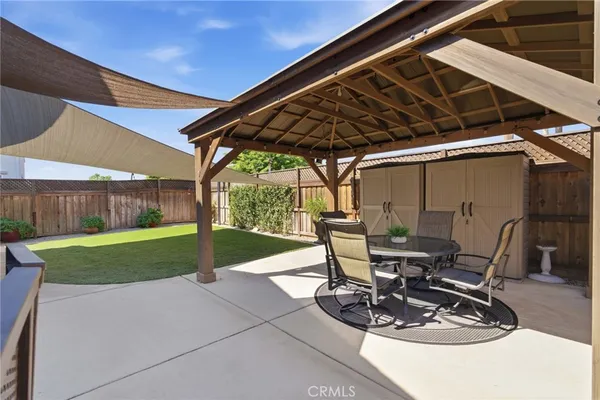 a view of a backyard with table and chairs and wooden fence