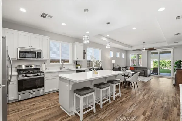 a large kitchen with lots of counter space a sink appliances and dining table
