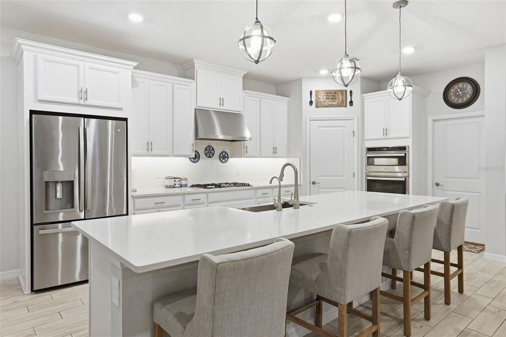 1271 Waterview Ridge Circle Apopka, FL 32703 - Photo 12 of 56 a kitchen with stainless steel appliances granite countertop a sink a stove a refrigerator cabinets and chairs