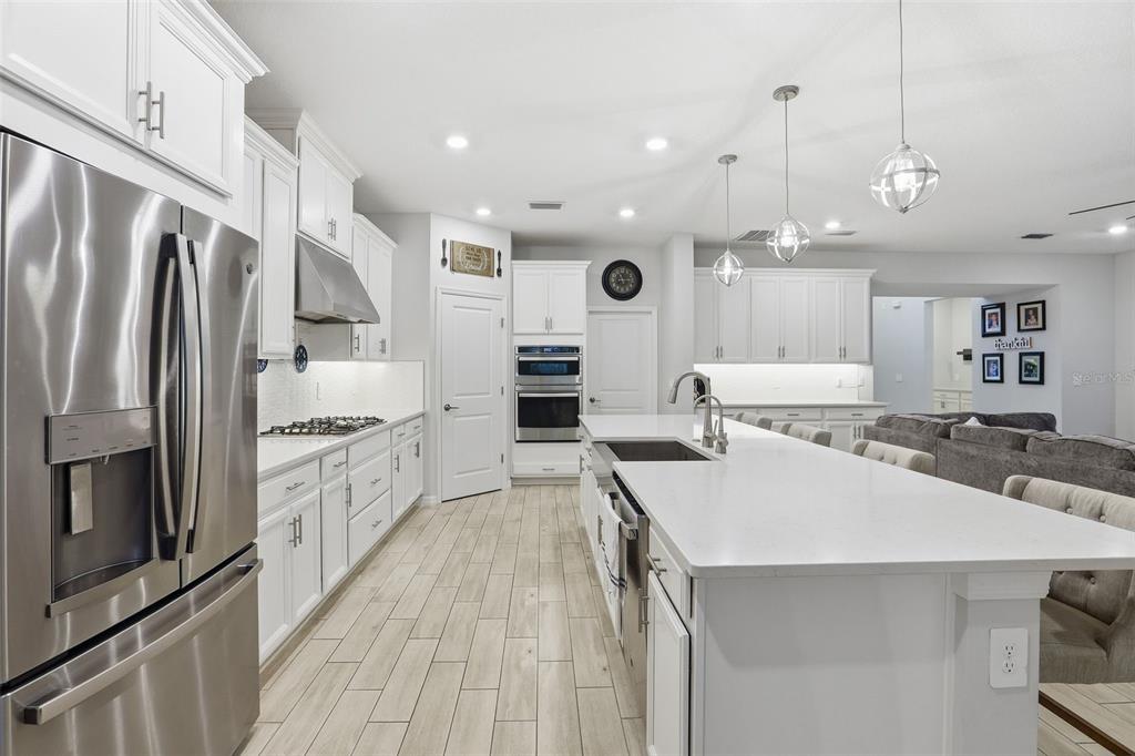 1271 Waterview Ridge Circle Apopka, FL 32703 - Photo 13 of 56 a large kitchen with kitchen island a large counter top space a sink stainless steel appliances and cabinets