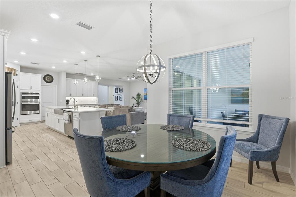 1271 Waterview Ridge Circle Apopka, FL 32703 - Photo 16 of 56 a dining room with furniture a chandelier and wooden floor