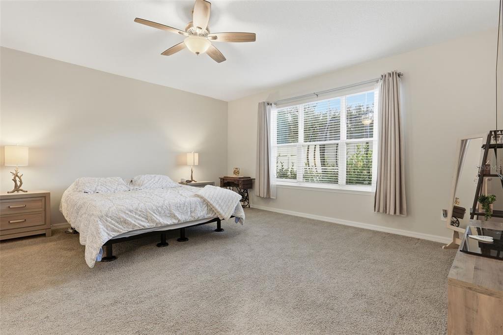1271 Waterview Ridge Circle Apopka, FL 32703 - Photo 17 of 56 a spacious bedroom with a bed a couch and a window