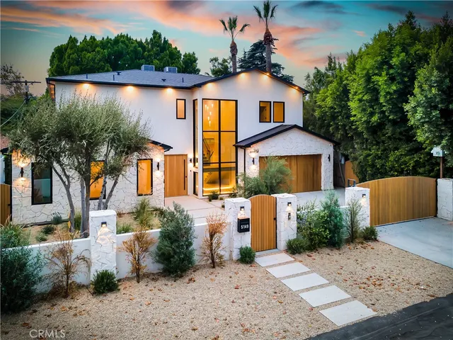 a front view of a house with a yard and lake view