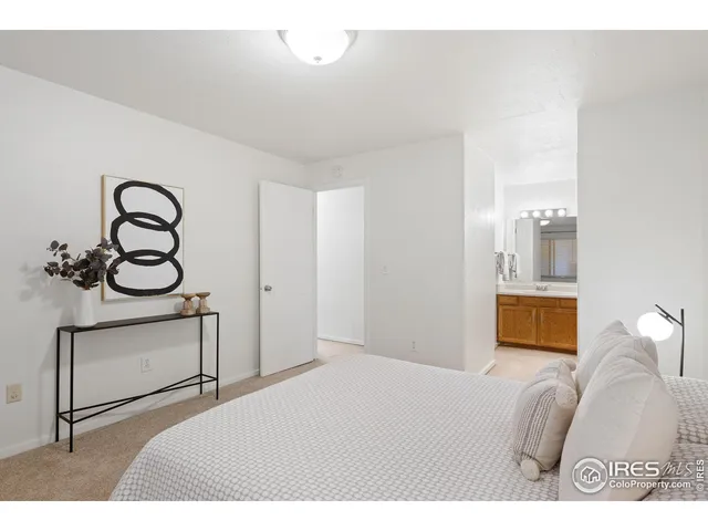 a bedroom with a bed and a painting on the wall