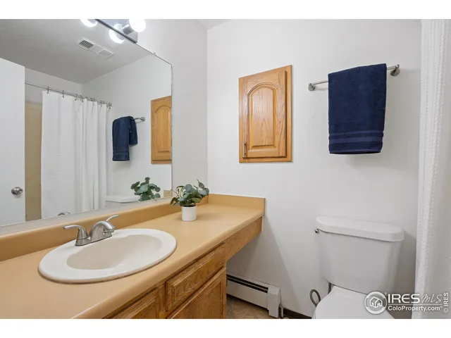 a bathroom with a sink vanity mirror and a toilet