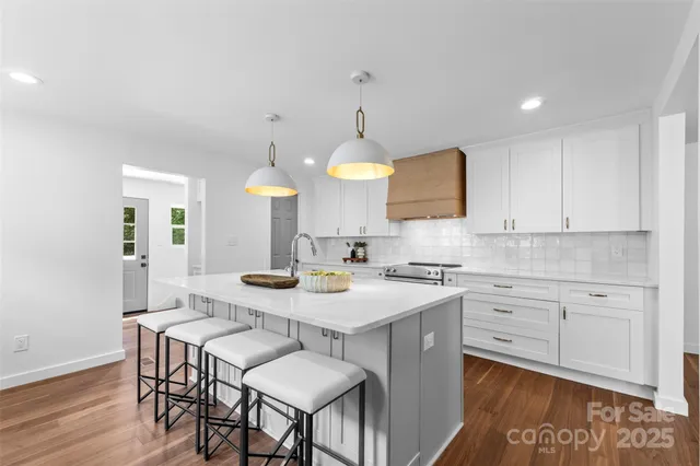a kitchen with a dining table cabinets and wooden floor