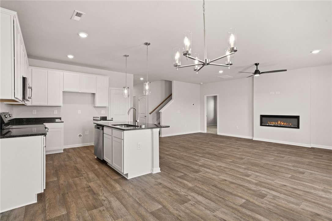 629 Silver Fir Street Piedmont, SC 29673 - Photo 15 of 36 This inviting space combines a functional kitchen island with a cozy fireplace, perfect for gatherings.
