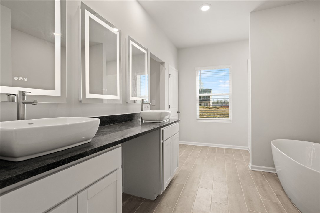 629 Silver Fir Street Piedmont, SC 29673 - Photo 20 of 36 This spacious bathroom offers dual vanities, modern fixtures, and a bright window with expansive views.