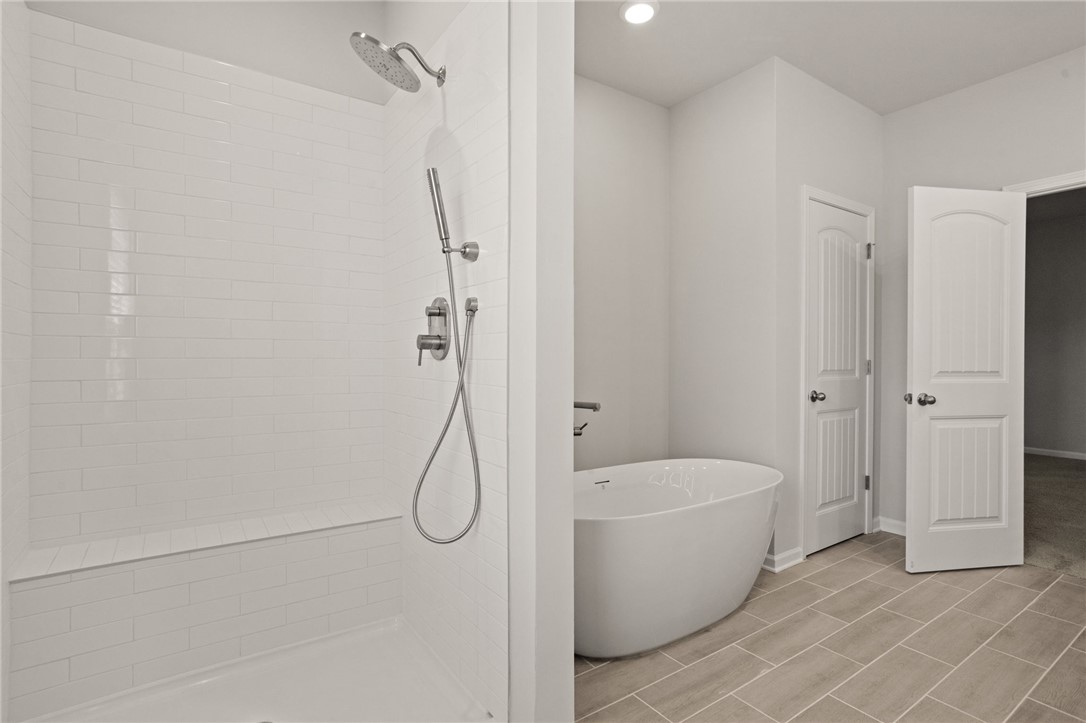 629 Silver Fir Street Piedmont, SC 29673 - Photo 21 of 36 This serene bathroom offers a spacious walk-in shower alongside a luxurious soaking tub.