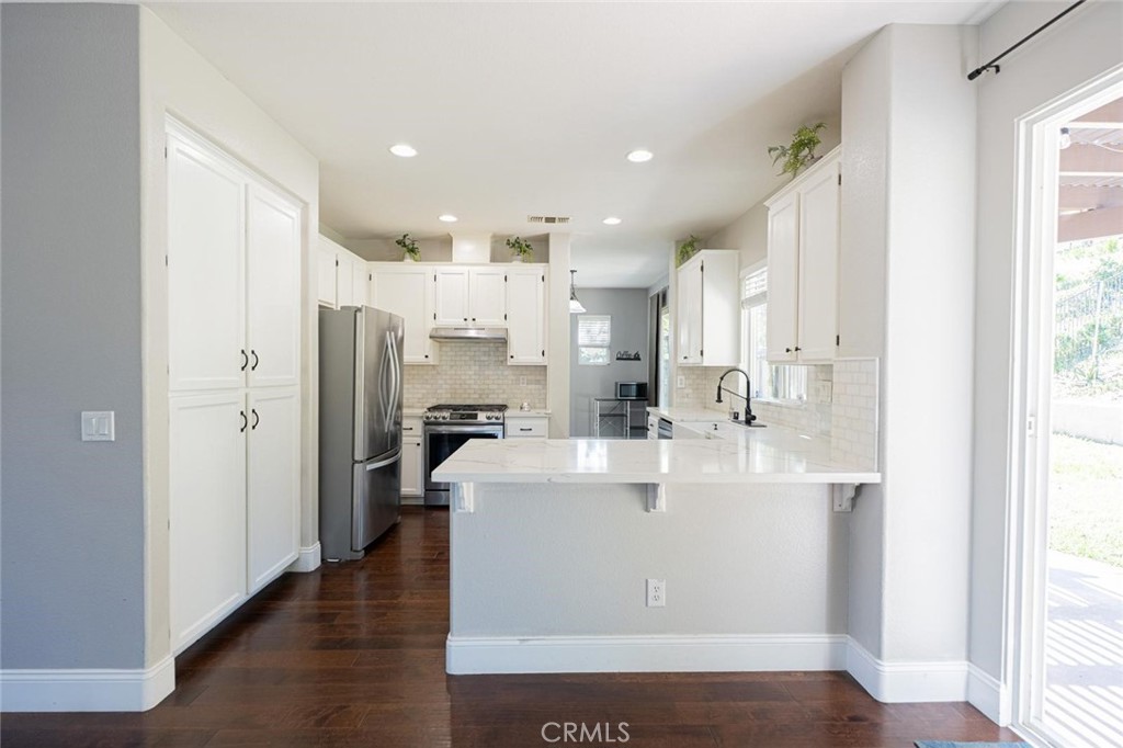 40601 Cebu Street Temecula, CA 92591 - Photo 11 of 26 a large white kitchen with a large window and stainless steel appliances