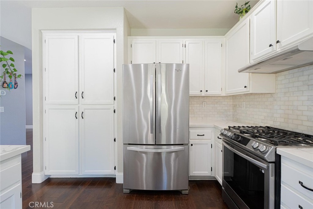 40601 Cebu Street Temecula, CA 92591 - Photo 13 of 26 a kitchen with a refrigerator stove and white cabinets