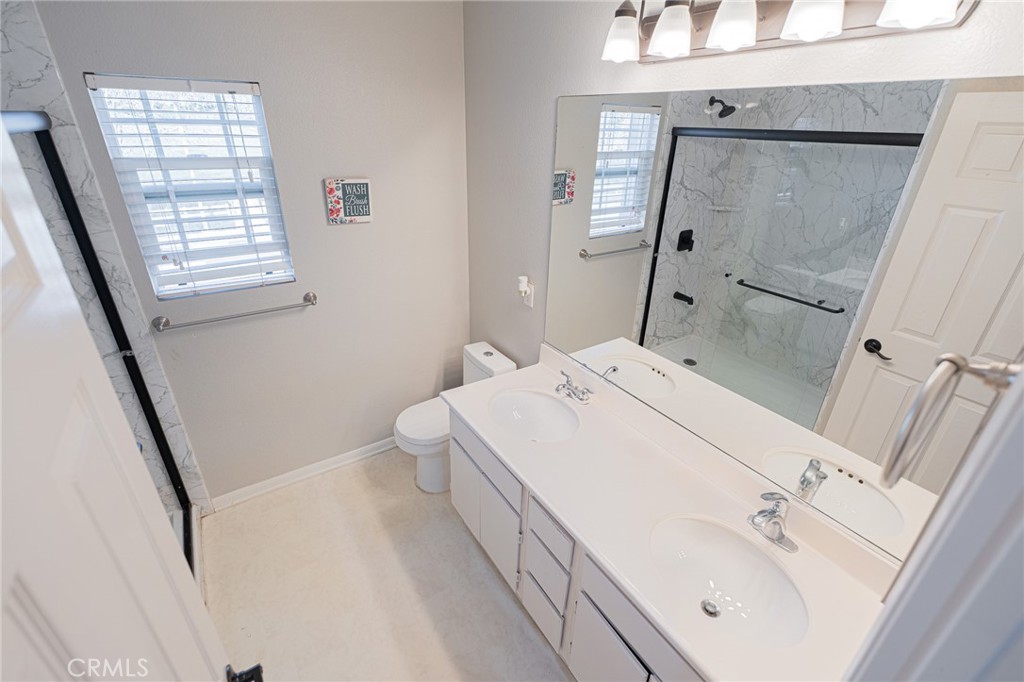 40601 Cebu Street Temecula, CA 92591 - Photo 18 of 26 a en suite bathroom with a sink a mirror and a shower