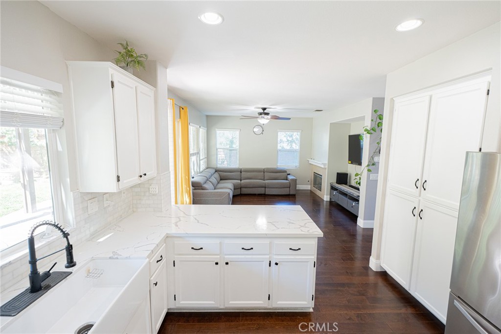 40601 Cebu Street Temecula, CA 92591 - Photo 8 of 26 a large kitchen with stainless steel appliances a refrigerator a sink a stove and white cabinets with wooden floor