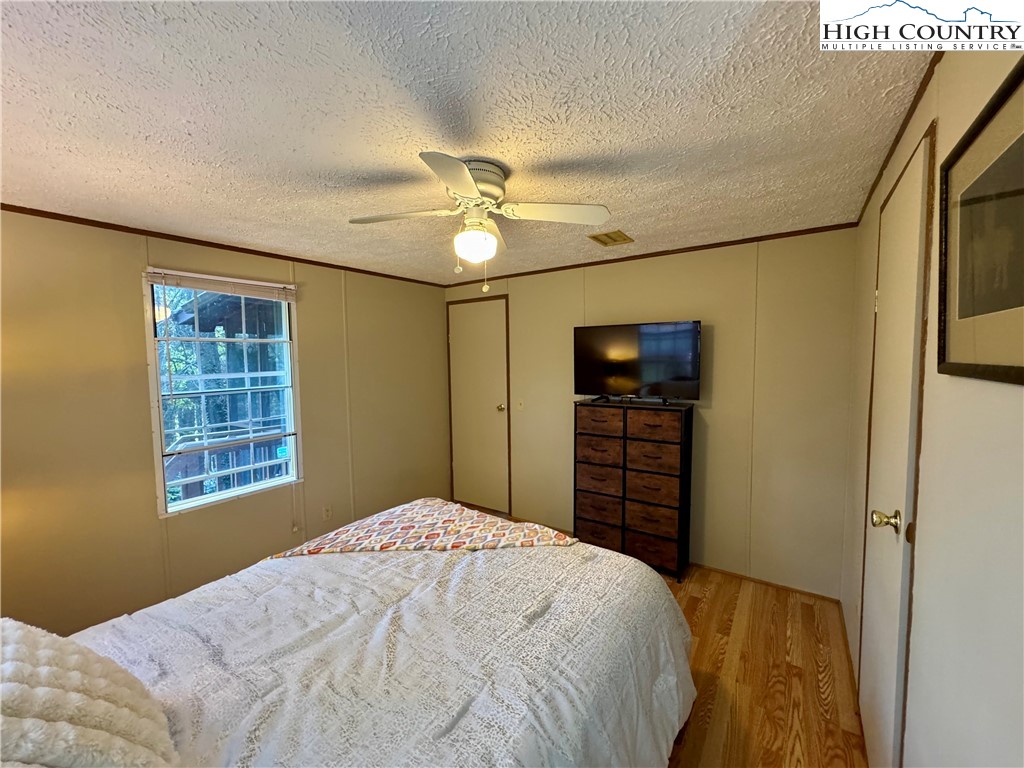 496 Laurelwood Lane Boone, NC 28607 - Photo 11 of 45 a bedroom with a bed and a chandelier
