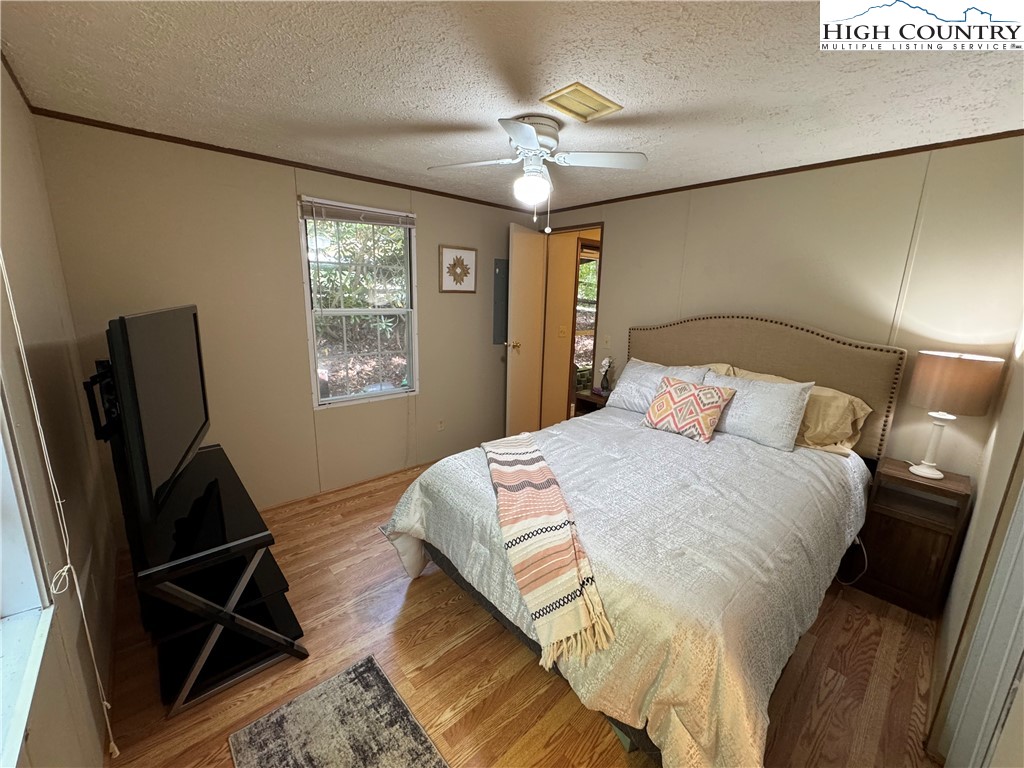 496 Laurelwood Lane Boone, NC 28607 - Photo 13 of 45 a bedroom with a bed and a chandelier