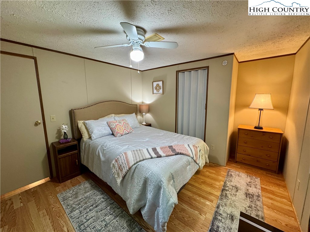 496 Laurelwood Lane Boone, NC 28607 - Photo 14 of 45 a bedroom with a bed and a chandelier