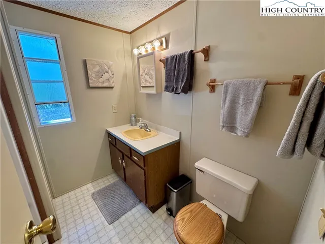 a bathroom with a toilet sink vanity tub and mirror