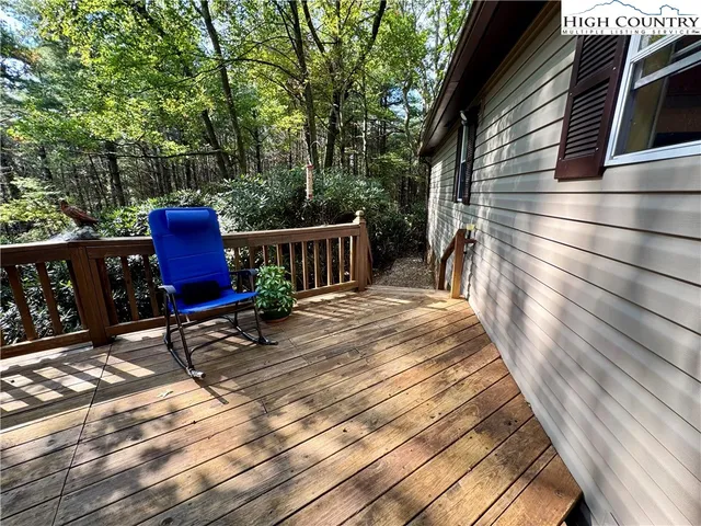 a view of backyard with wooden fence and a large tree