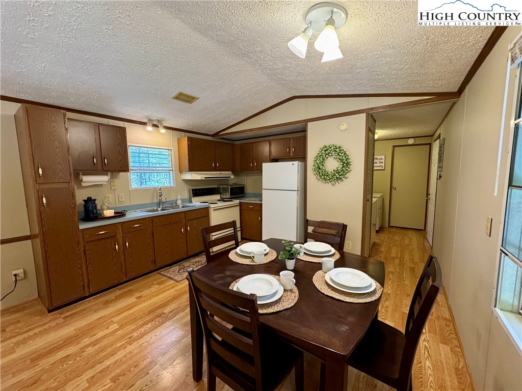 496 Laurelwood Lane Boone, NC 28607 - Photo 9 of 45 a kitchen with stainless steel appliances granite countertop a sink a stove a refrigerator with a dining table and chairs