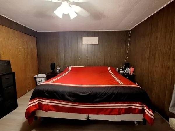 a bed sitting in a spacious bedroom next to a window