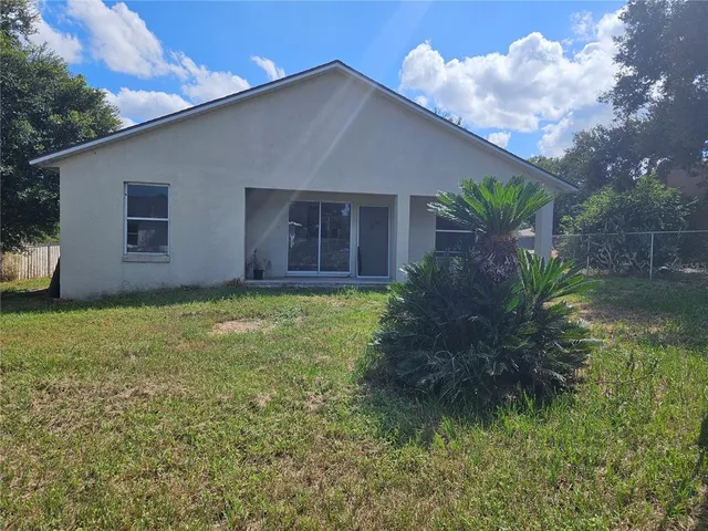 a house with a yard plants and large tree