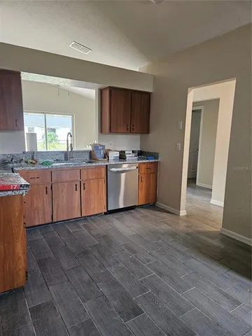 a large kitchen with stainless steel appliances granite countertop a stove a sink and a refrigerator