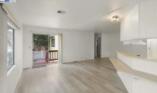 a view of a room with wooden floor and a window