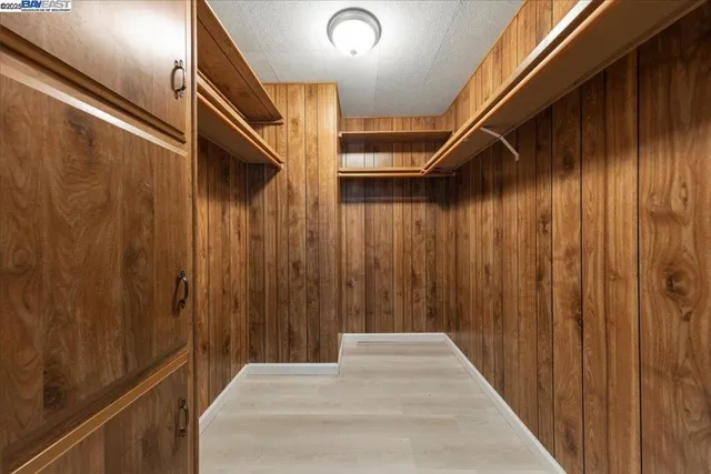 a view of an empty room with closet and a window