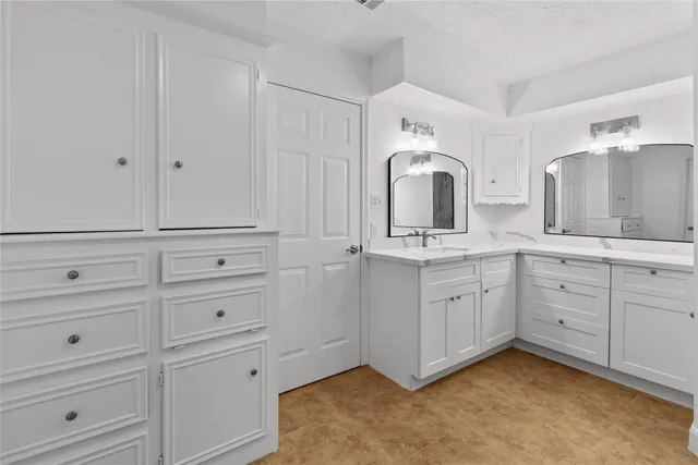 a kitchen with kitchen island granite countertop a sink cabinets and stainless steel appliances