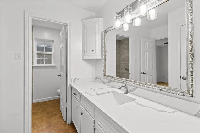 a bathroom with a toilet sink vanity and mirror