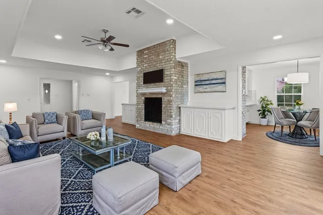 an empty room with windows fireplace and a kitchen view