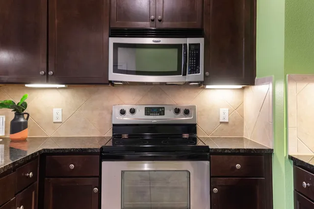 a kitchen with stainless steel appliances granite countertop a stove and a microwave