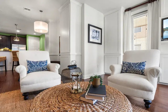 a living room with furniture wooden floor and wall painting
