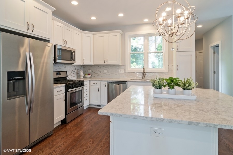 204 Fairbank Road Riverside, IL 60546 - Photo 7 of 24 a kitchen with stainless steel appliances granite countertop a refrigerator a sink dishwasher a stove and white cabinets with wooden floor