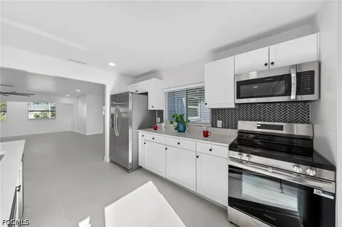 a kitchen with appliances a sink and cabinets