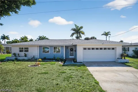 a view of a house with a yard and potted plants