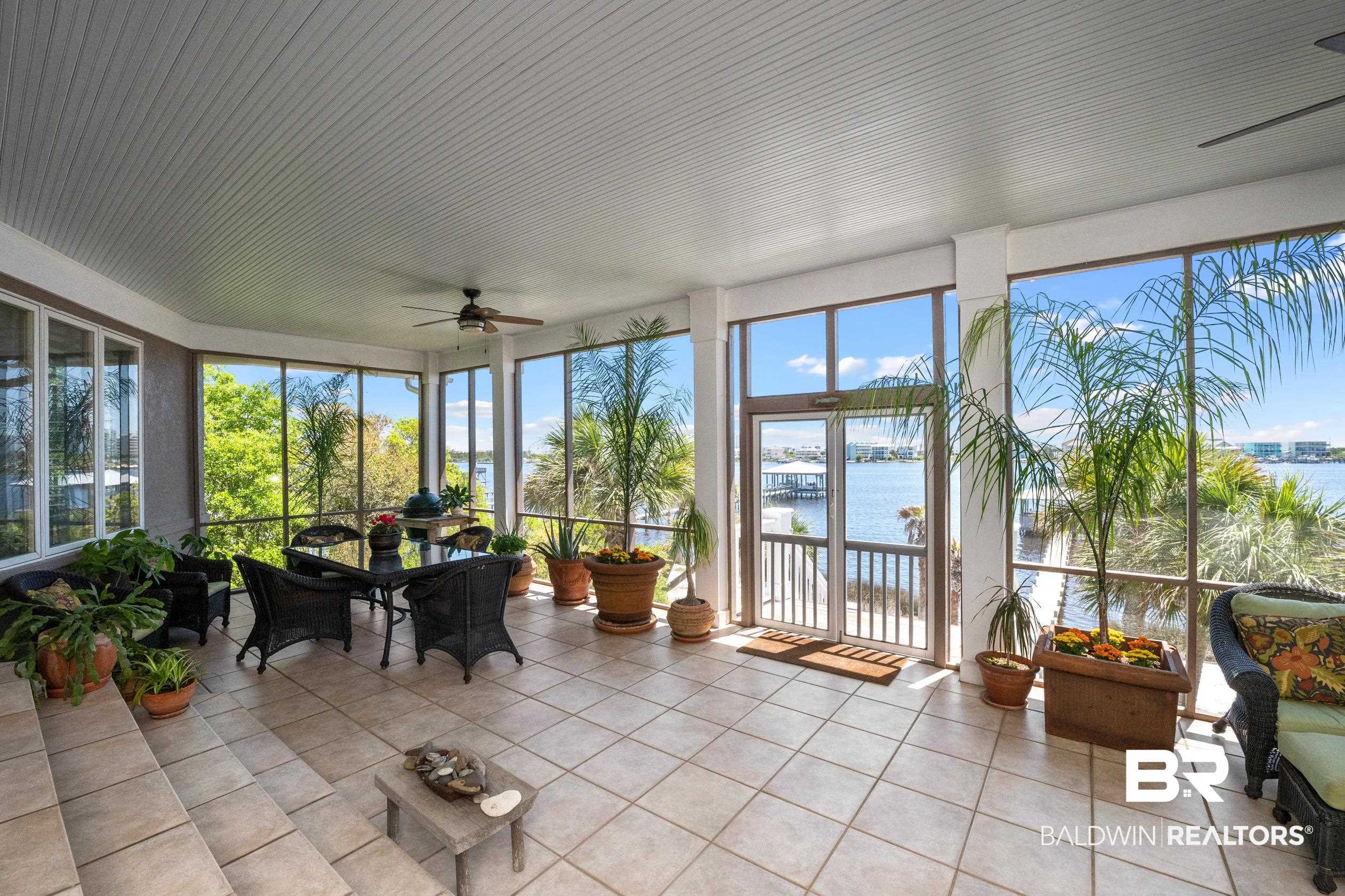 31304 River Road Orange Beach, AL 36561 - Photo 13 of 78 Sunroom with tile patterned floors, a wealth of natural light, and a water view