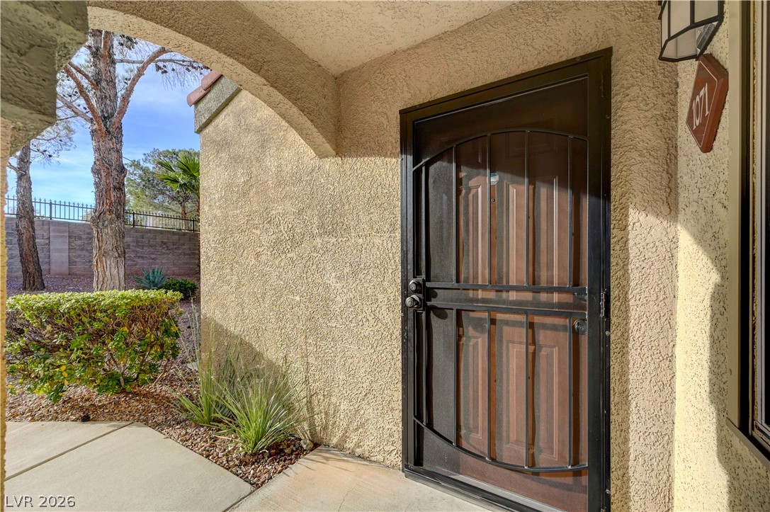 7885 West Flamingo Road, Unit 1071 Las Vegas, NV 89147 - Photo 6 of 28 Welcome home through a secure front door with ornate ironwork, complementing the textured stucco facade.