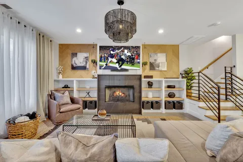 a living room with furniture a fireplace and a chandelier