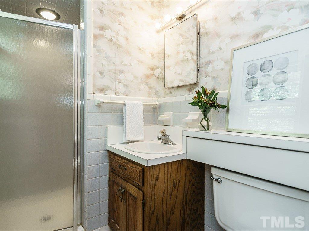 4305 Rowan Street Raleigh, NC 27609 - Photo 14 of 22 a bathroom with a sink a vanity and a mirror