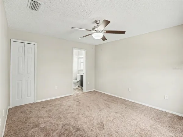 a view of an empty room and a ceiling fan