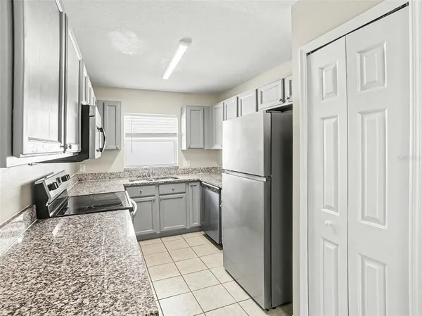 a kitchen with stainless steel appliances granite countertop a refrigerator and a sink